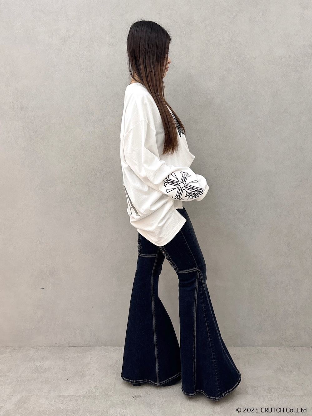 ホワイト系のTシャツ/カットソー、ブルー系のデニムパンツ、ブラック系のブーツを着用したレディースの秋コーディネートの2枚目の写真