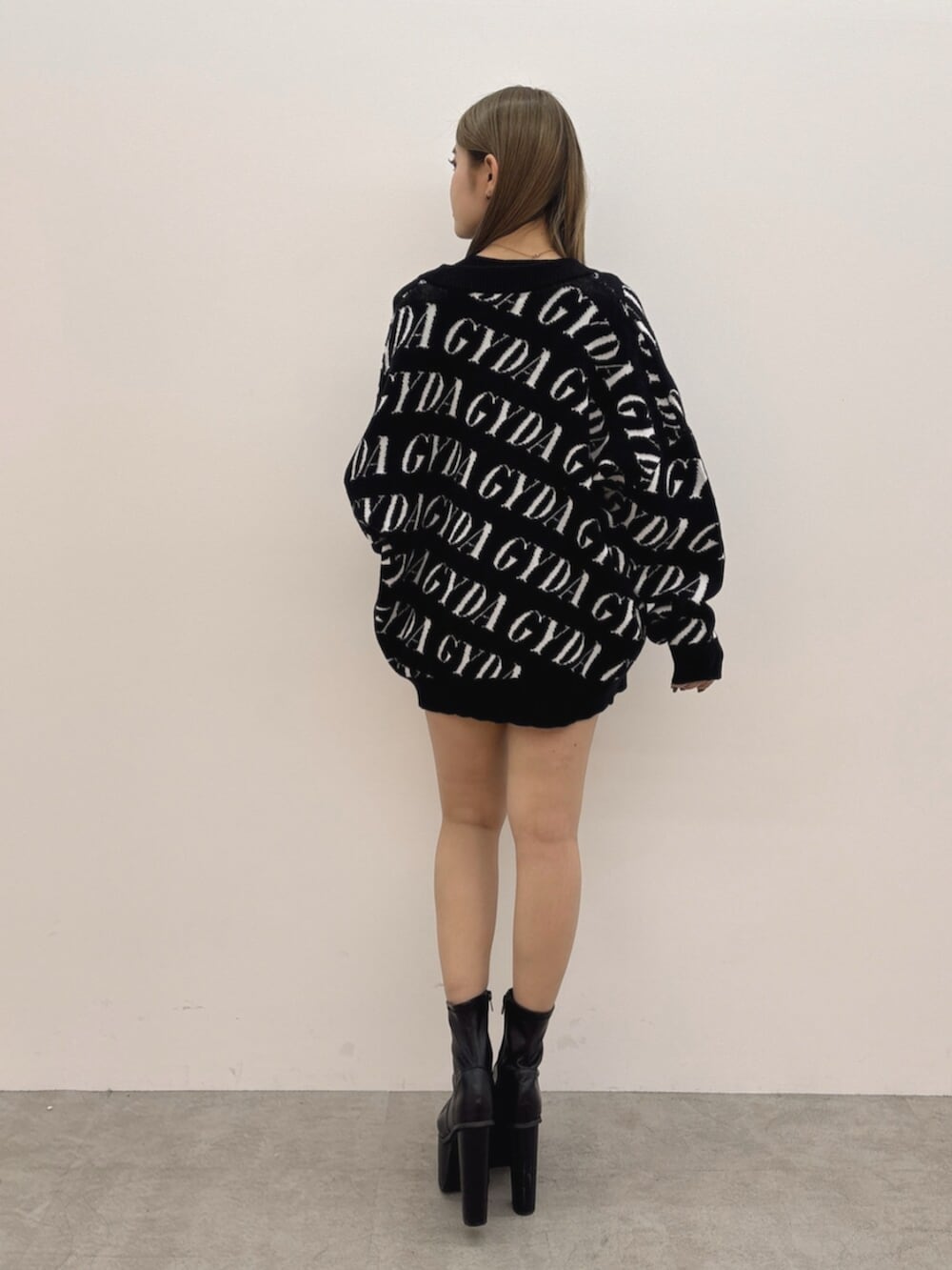 ブラック系のブーツ、ブラック系のTシャツ/カットソー、グレー系のスカートを着用したレディースの冬コーディネートの4枚目の写真