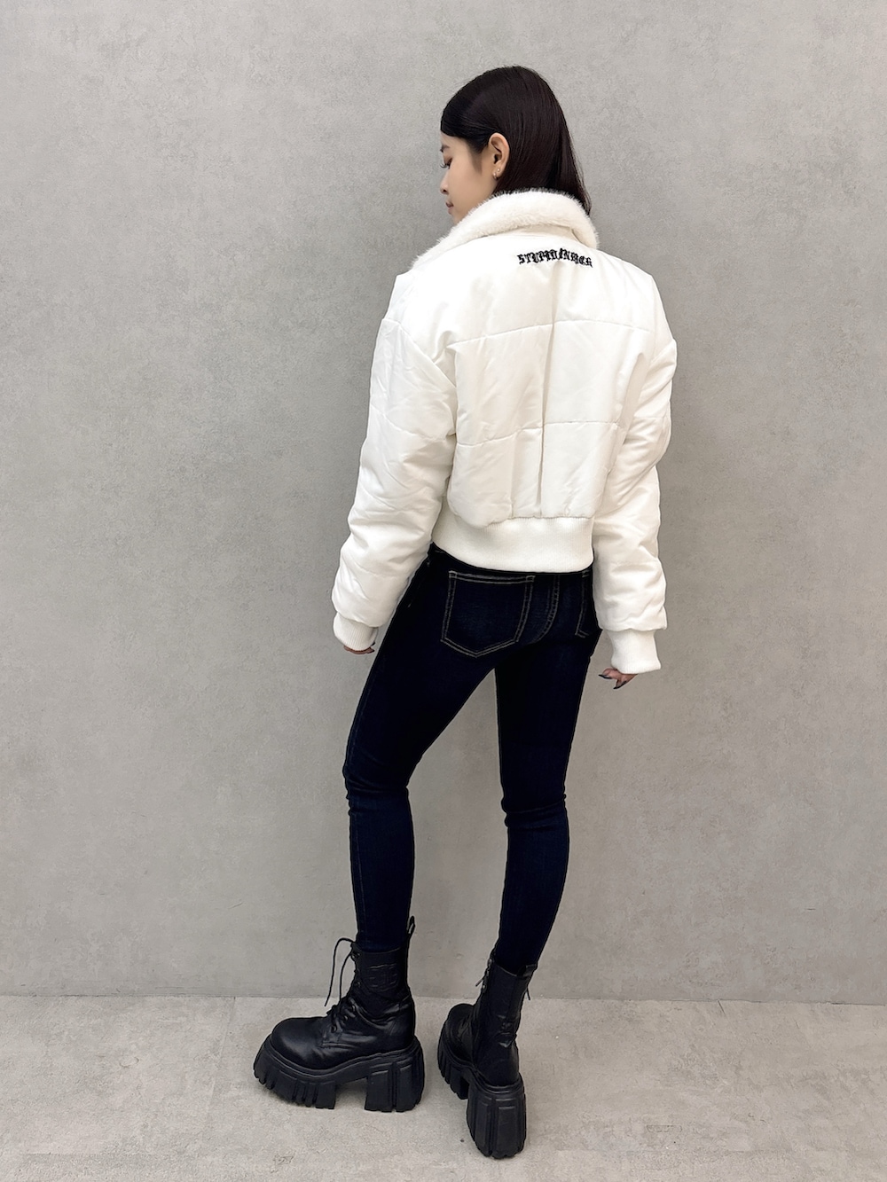 ブラック系のブーツ、ブルー系のデニムパンツ、ブラック系のTシャツ/カットソーを着用したレディースの秋コーディネートの3枚目の写真