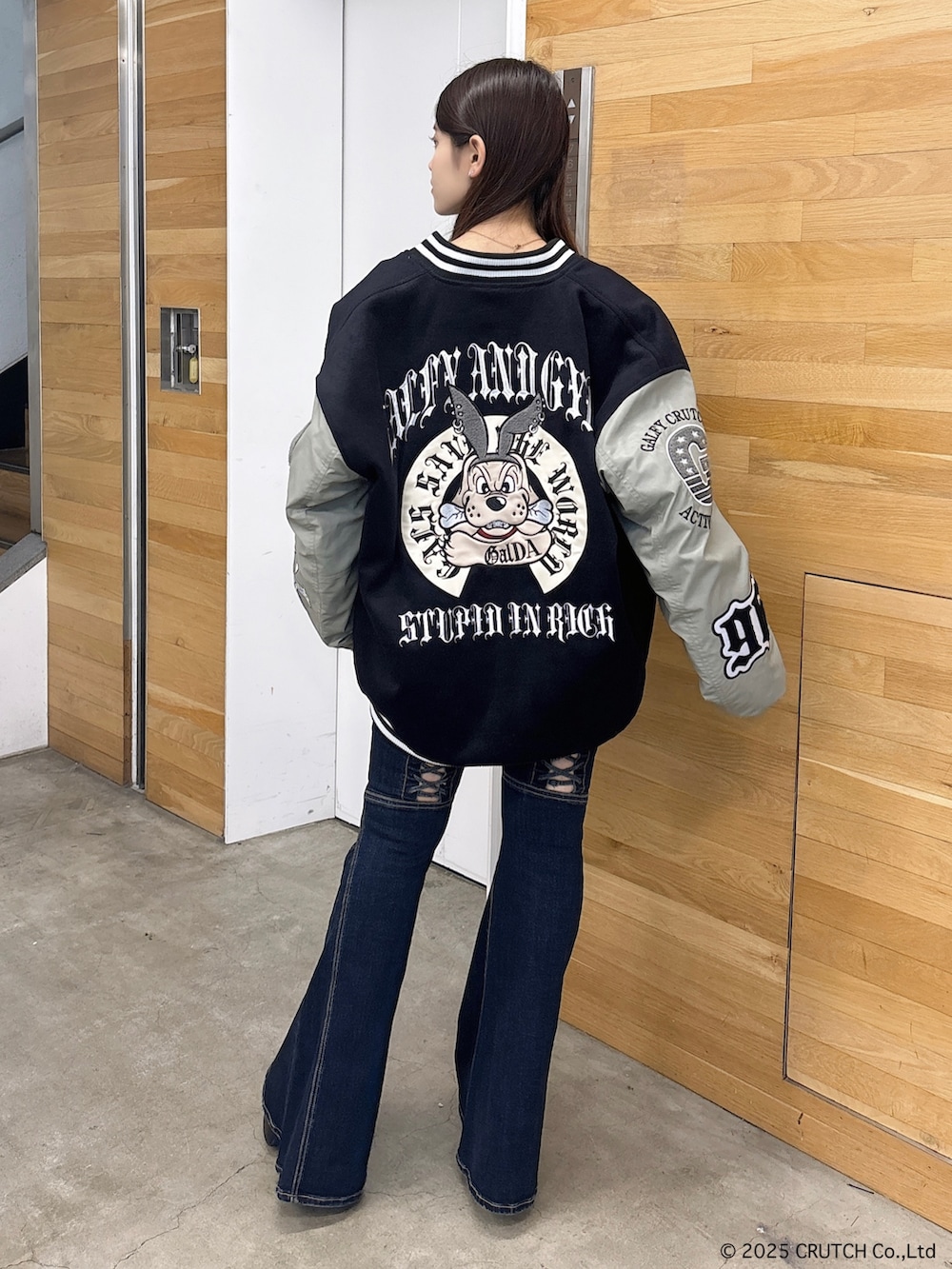 ブラック系のスタジャン、ホワイト系のニット/セーター、ブルー系のデニムパンツを着用したレディースの秋コーディネートの3枚目の写真