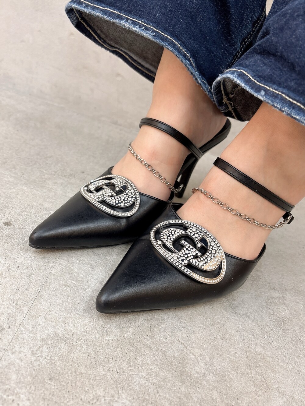 ホワイト系のニット/セーター、ブルー系のデニムパンツ、ブラック系のパンプスを着用したレディースの春コーディネートの6枚目の写真