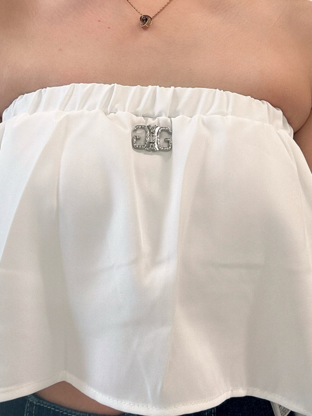 ブルー系のデニムパンツ、ブラック系のサンダル、ホワイト系のチューブトップを着用したレディースの夏コーディネートの5枚目の写真
