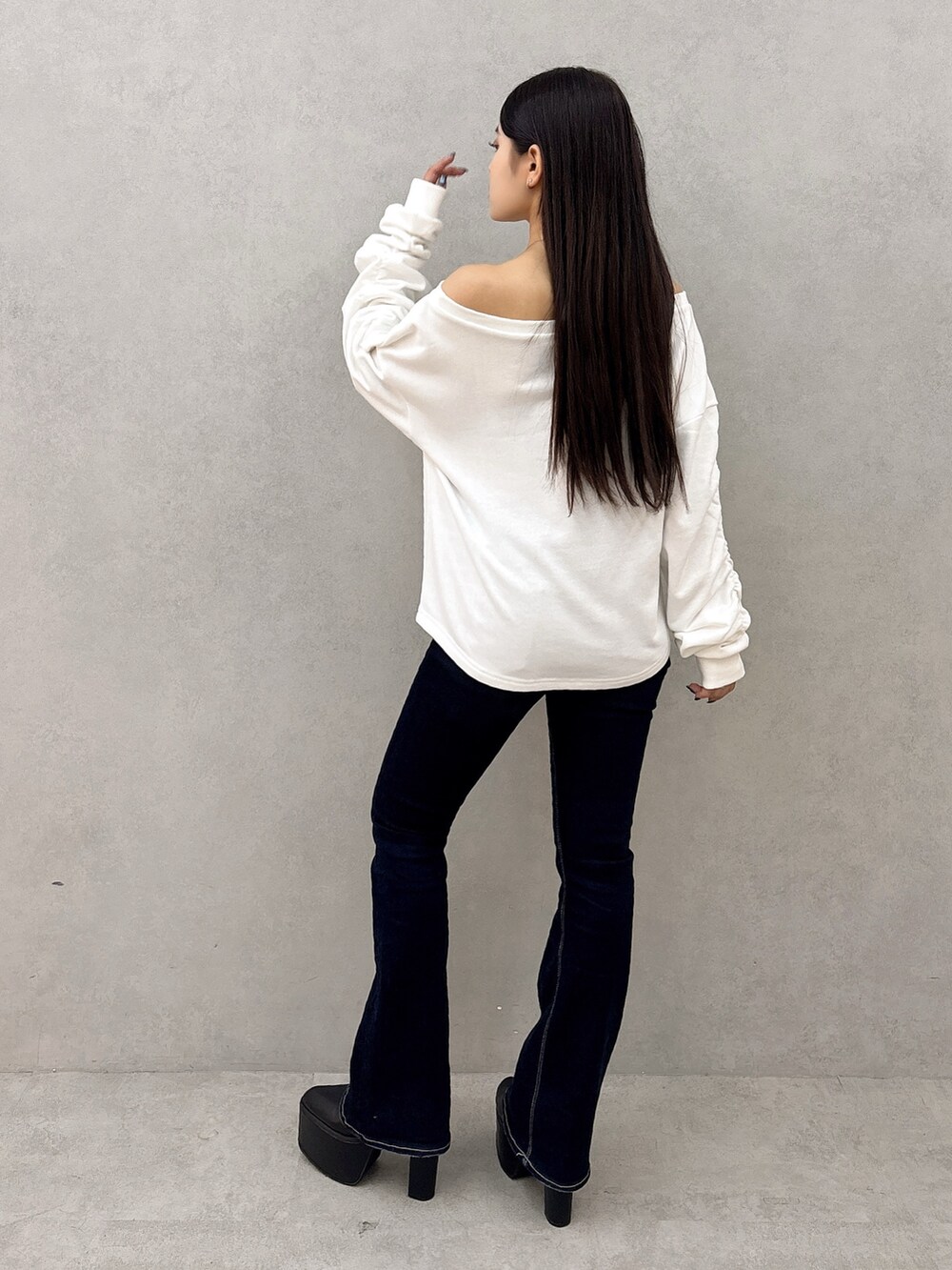 ホワイト系のスウェット、ブルー系のデニムパンツ、ブラック系のブーツを着用したレディースの秋コーディネートの3枚目の写真