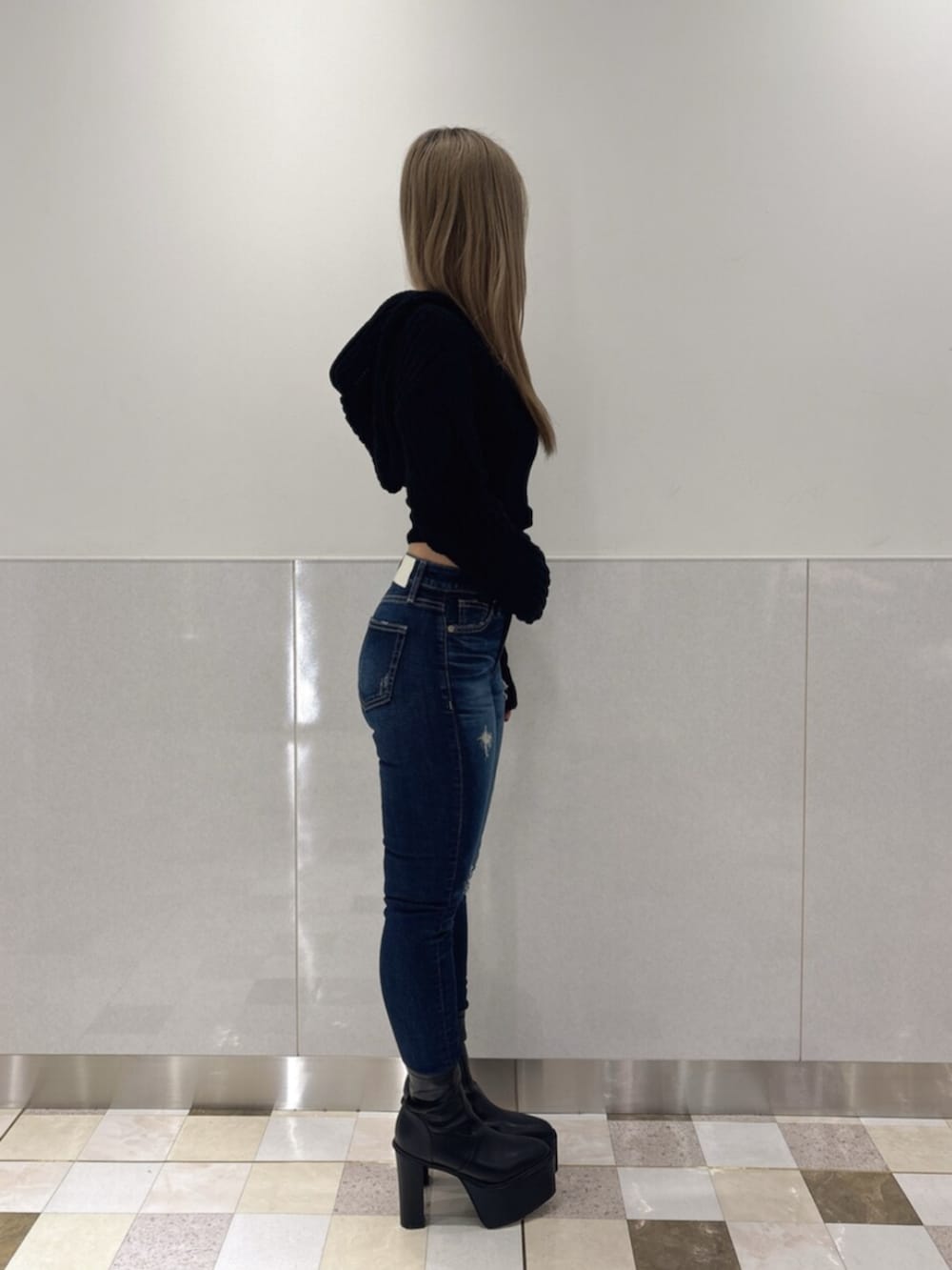 ブルー系のデニムパンツ、ブラック系のブーツ、ブラック系のニット/セーターを着用したレディースの秋コーディネートの2枚目の写真