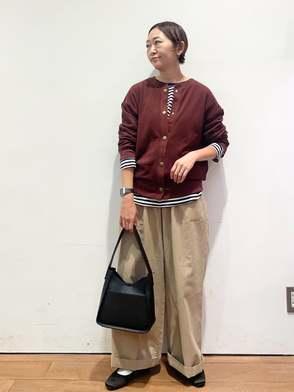 レッド系のカーディガン/ボレロ、ホワイト系のTシャツ/カットソー、ブラック系のハンドバッグを着用したレディースの秋コーディネートの2枚目の写真