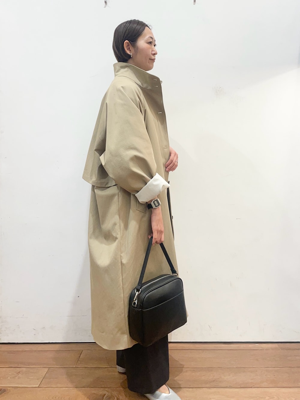 ベージュ系のその他アウター、ブラック系のニット/セーター、シルバー系のパンプスを着用したレディースの春コーディネートの3枚目の写真