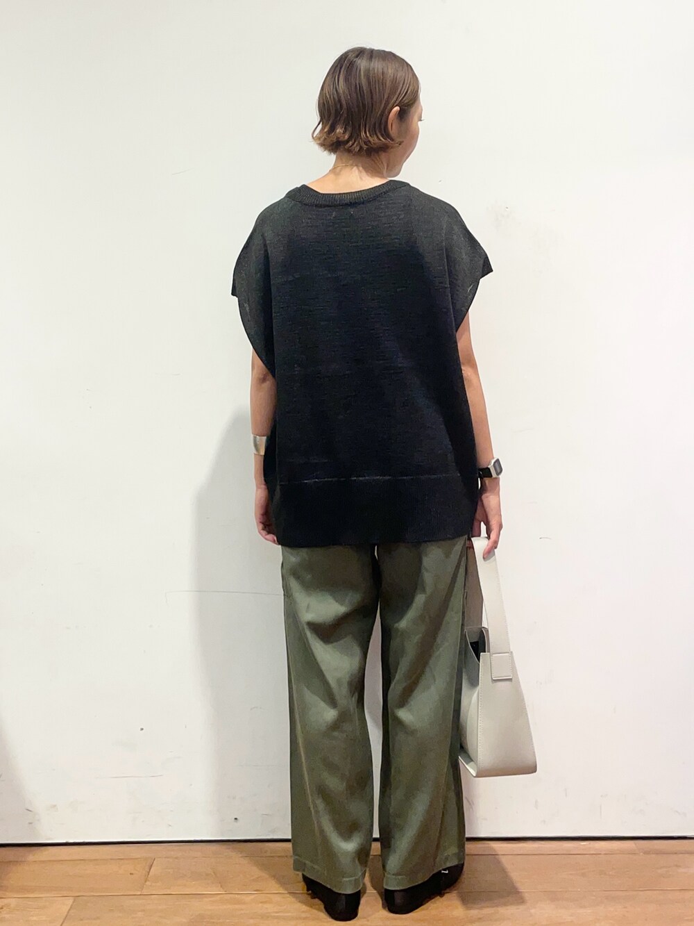 ブラック系のニット/セーター、グレー系のハンドバッグ、グリーン系のその他パンツを着用したレディースの秋コーディネートの5枚目の写真