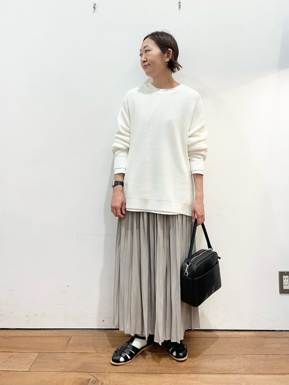 ホワイト系のニット/セーター、ホワイト系のTシャツ/カットソー、ベージュ系のスカートを着用したレディースの春コーディネートの2枚目の写真