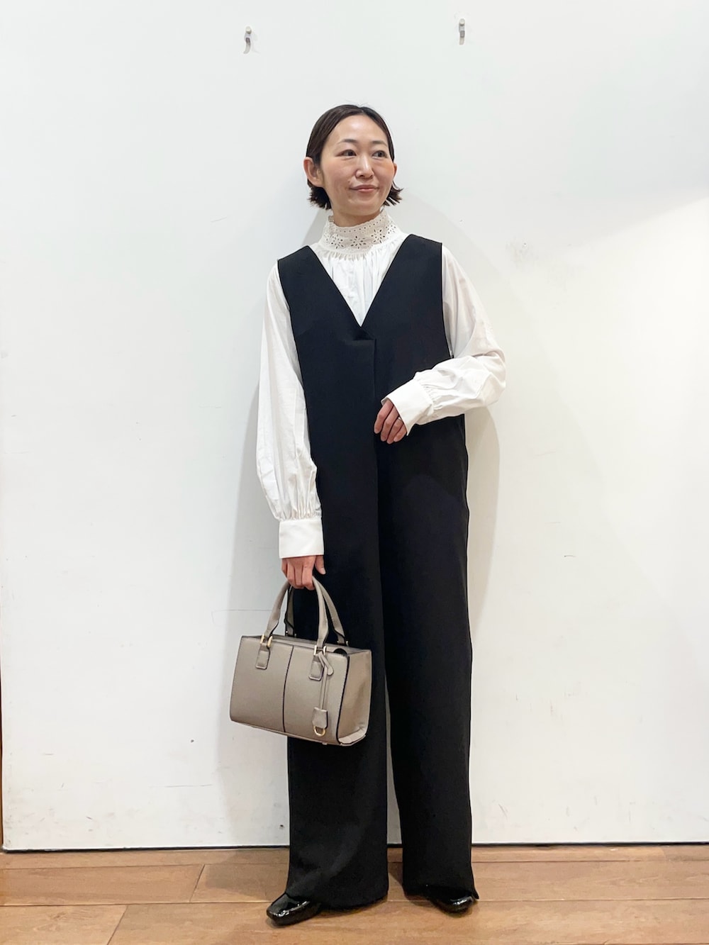 ブラック系のその他パンツ、ホワイト系のシャツ/ブラウス、グレー系のハンドバッグを着用したレディースの冬コーディネートの2枚目の写真