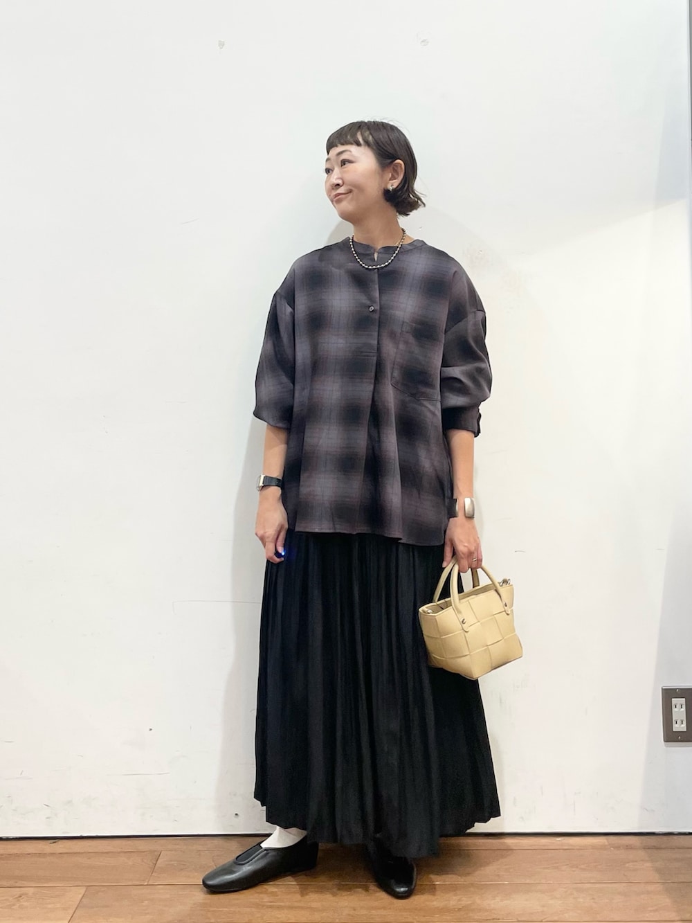 ベージュ系のハンドバッグ、グレー系のシャツ/ブラウス、ブラック系のスカートを着用したレディースの秋コーディネートの3枚目の写真