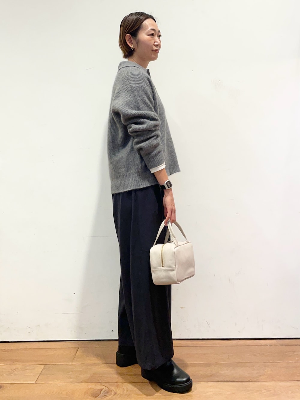 グレー系のニット/セーター、グレー系のボストンバッグ、ブルー系のその他パンツを着用したレディースの秋コーディネートの4枚目の写真