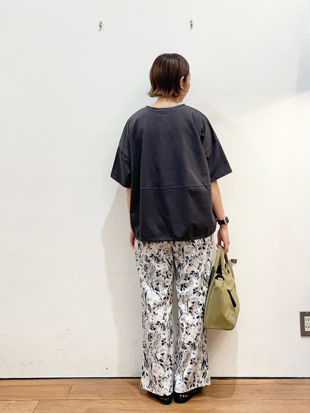 グレー系のTシャツ/カットソー、ブラック系のサンダル、ベージュ系のトートバッグを着用したレディースの春コーディネートの4枚目の写真