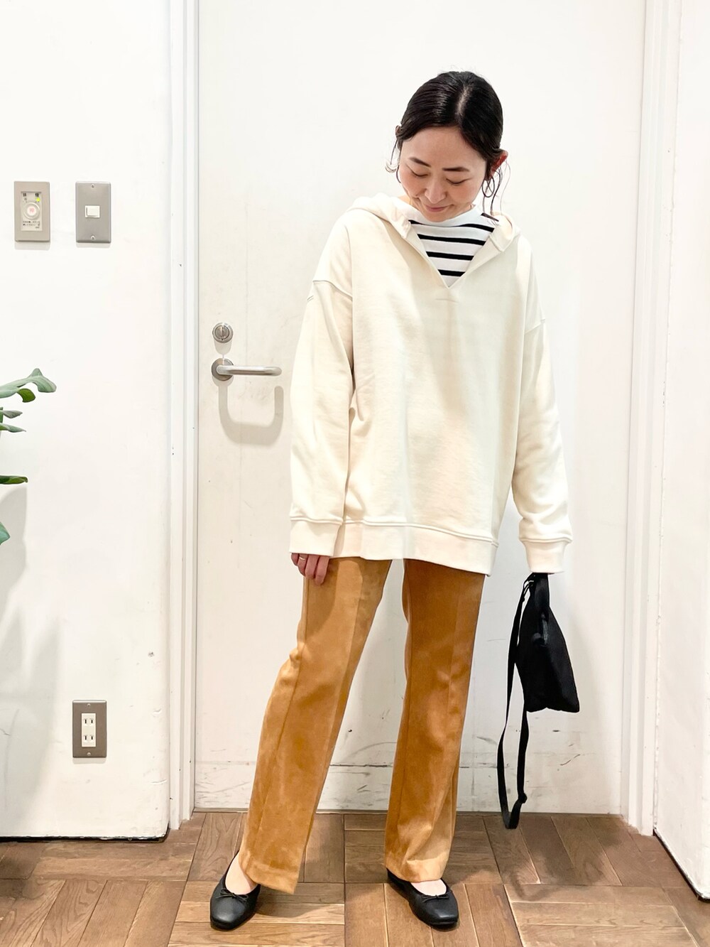 ブラック系のTシャツ/カットソー、ホワイト系のパーカー、イエロー系のその他パンツを着用したレディースの冬コーディネートの2枚目の写真