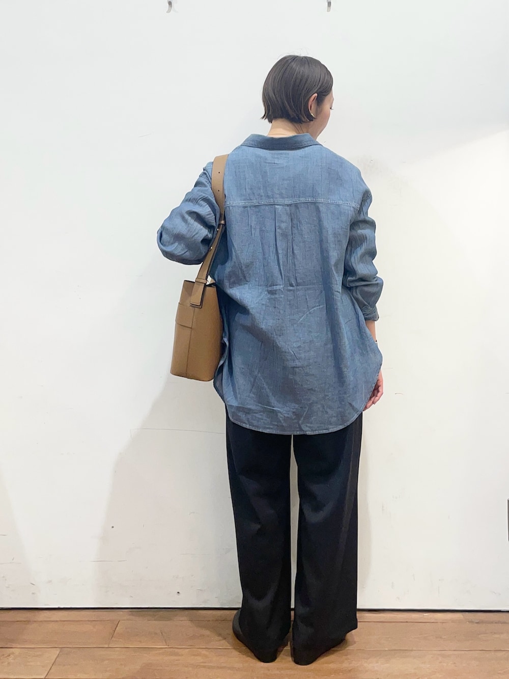 ブルー系のシャツ/ブラウス、ブラック系のパンプス、イエロー系のショルダーバッグを着用したレディースの春コーディネートの5枚目の写真