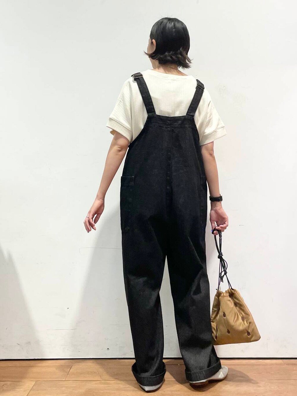 ホワイト系のTシャツ/カットソー、ブラウン系のバレエシューズ、ブラック系のサロペット/オーバーオールを着用したレディースの秋コーディネートの6枚目の写真