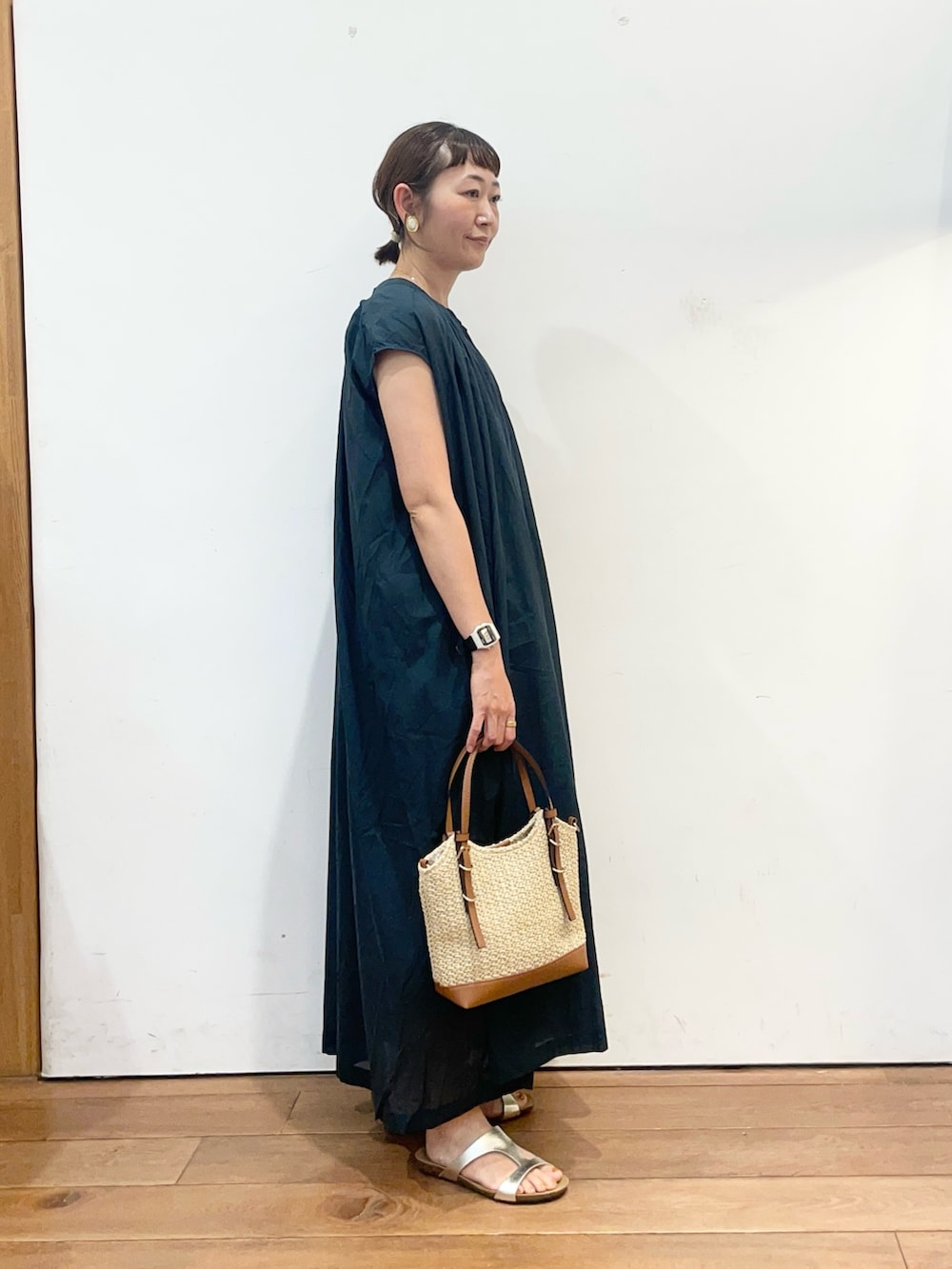 グリーン系のワンピース、イエロー系のショルダーバッグ、ゴールド系のサンダルを着用したレディースの夏コーディネートの4枚目の写真