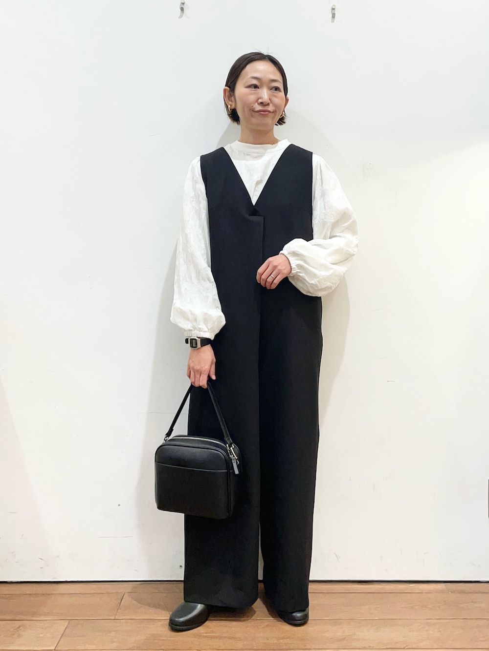 ブラック系のその他パンツ、ブラック系のショルダーバッグ、ブラック系のブーツを着用したレディースの冬コーディネートの3枚目の写真