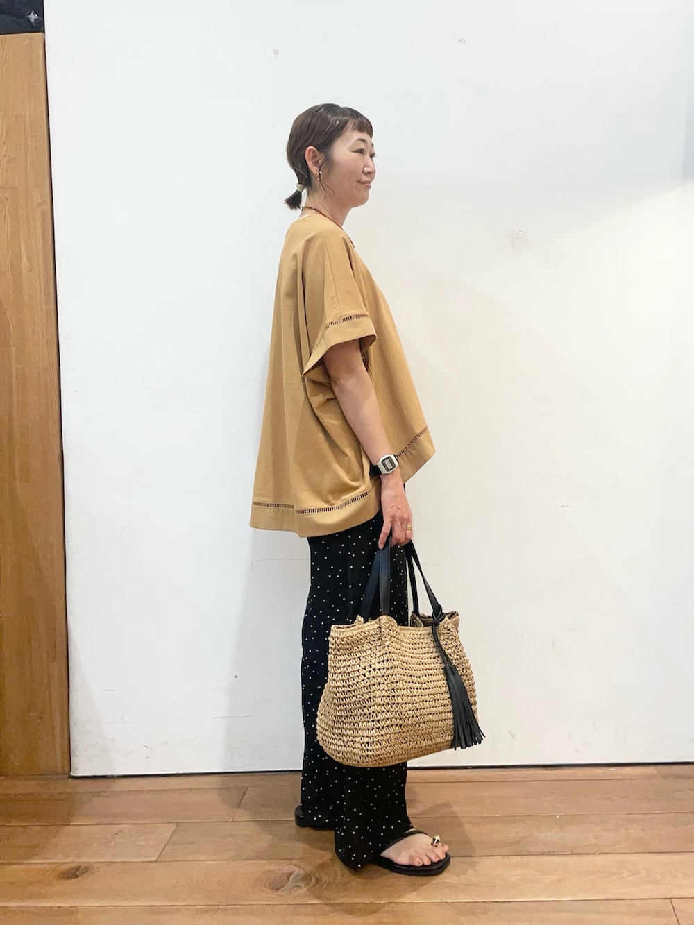 イエロー系のTシャツ/カットソー、ブラック系のその他パンツ、イエロー系のかごバッグを着用したレディースの夏コーディネートの3枚目の写真