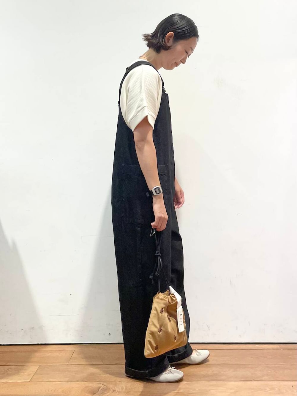 ホワイト系のTシャツ/カットソー、ブラウン系のバレエシューズ、ブラック系のサロペット/オーバーオールを着用したレディースの秋コーディネートの5枚目の写真