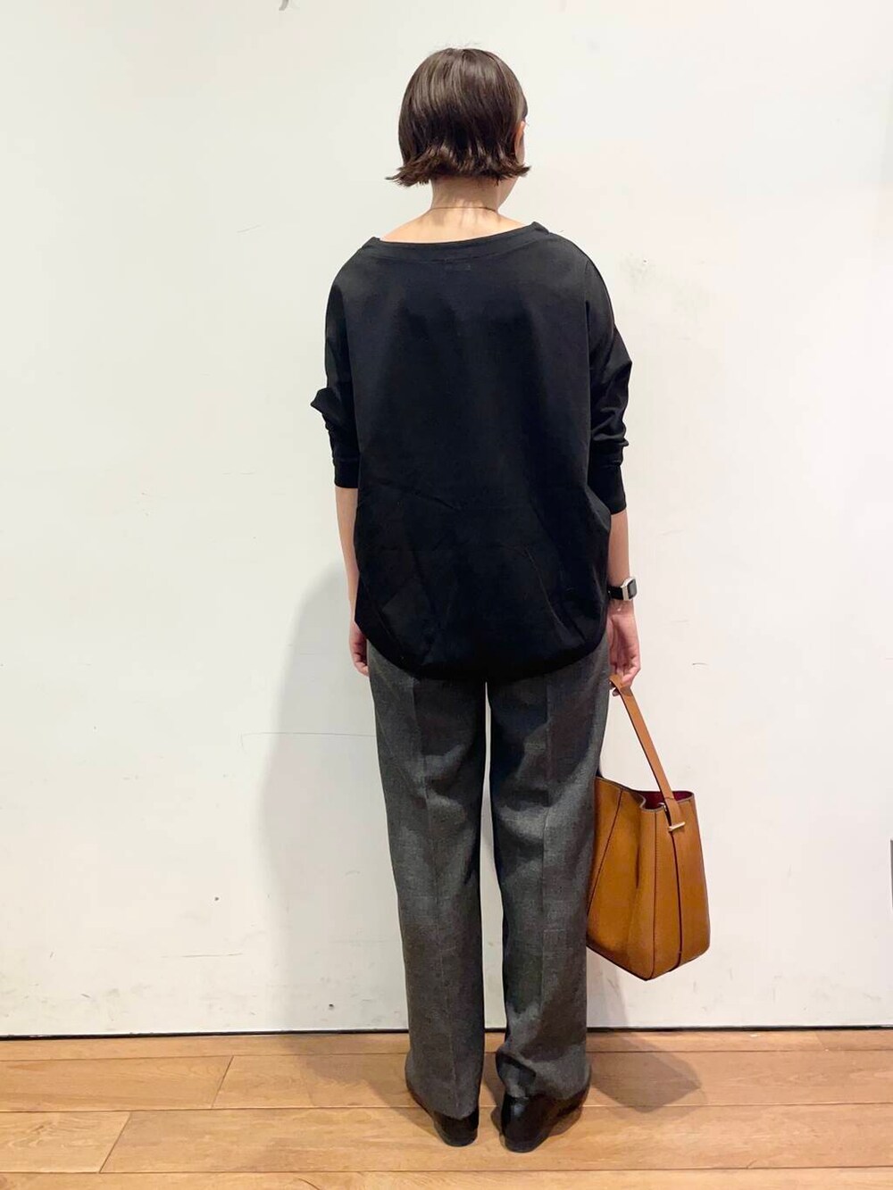 ブラウン系のハンドバッグ、ブラック系のTシャツ/カットソー、グレー系のその他パンツを着用したレディースの秋コーディネートの4枚目の写真