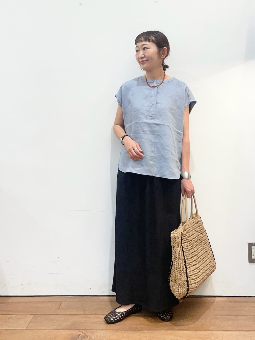 ブルー系のシャツ/ブラウス、ベージュ系のトートバッグ、ブラック系のサンダルを着用したレディースの夏コーディネートの2枚目の写真