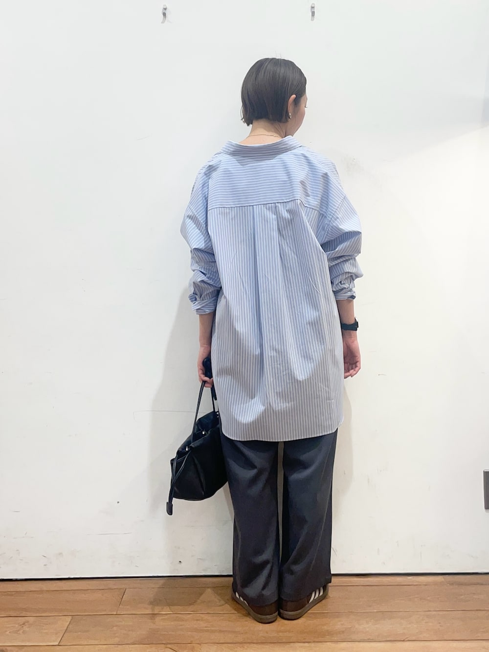 ブラック系のショルダーバッグ、ブルー系のシャツ/ブラウス、ブラウン系のTシャツ/カットソーを着用したレディースの春コーディネートの4枚目の写真