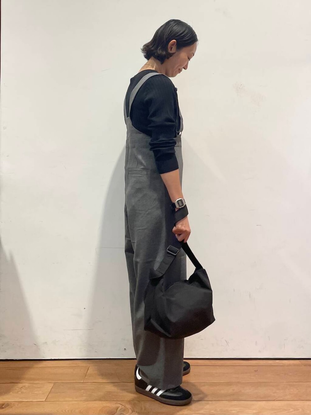 ブラック系のショルダーバッグ、グレー系のサロペット/オーバーオール、ブラック系のスニーカーを着用したレディースの秋コーディネートの6枚目の写真