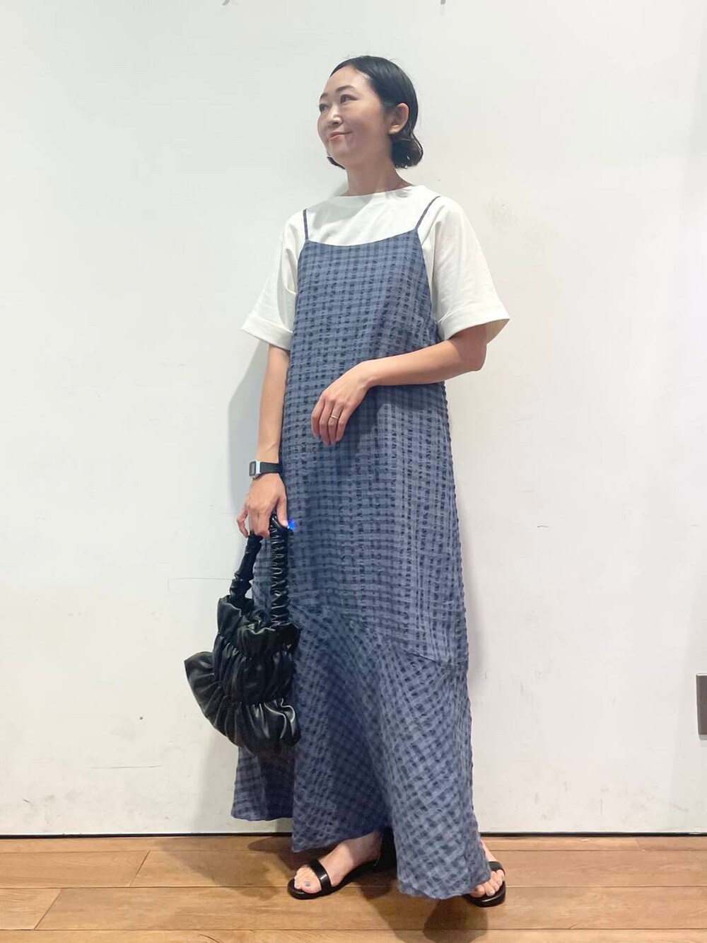 ブラック系のサンダル、ホワイト系のTシャツ/カットソー、ブラック系のハンドバッグを着用したレディースの夏コーディネートの3枚目の写真