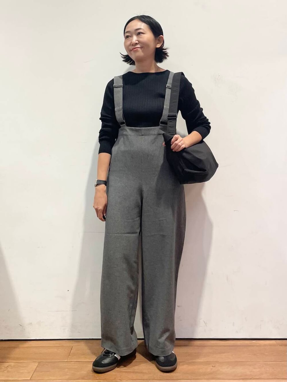 ブラック系のショルダーバッグ、グレー系のサロペット/オーバーオール、ブラック系のスニーカーを着用したレディースの秋コーディネートの5枚目の写真