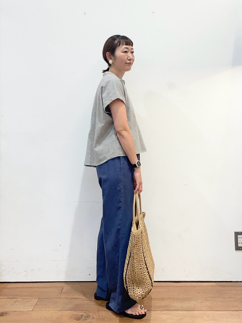 ブラック系のシャツ/ブラウス、ブルー系のその他パンツ、ベージュ系のトートバッグを着用したレディースの夏コーディネートの3枚目の写真