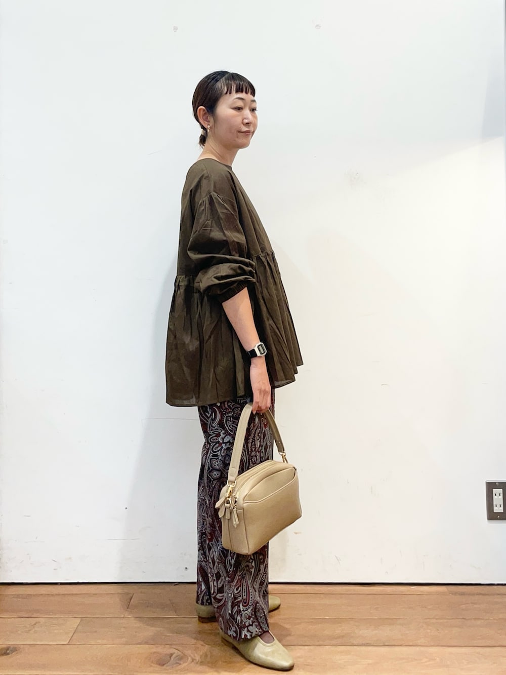 ブラウン系のシャツ/ブラウス、ベージュ系のショルダーバッグ、レッド系のその他パンツを着用したレディースの秋コーディネートの3枚目の写真