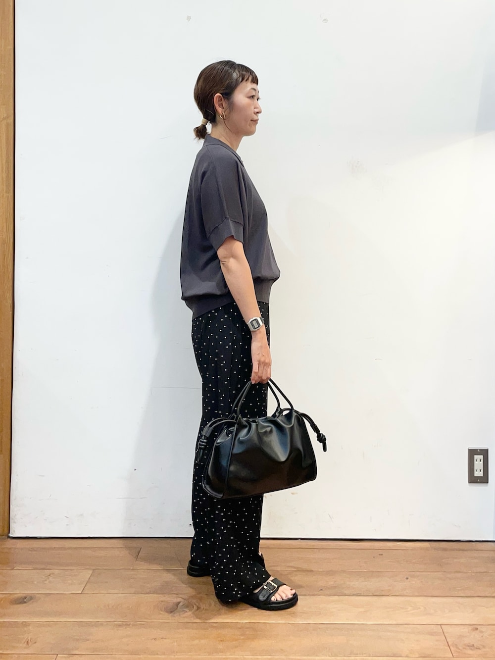 グレー系のニット/セーター、ブラック系のトートバッグ、ブラック系のサンダルを着用したレディースの夏コーディネートの4枚目の写真