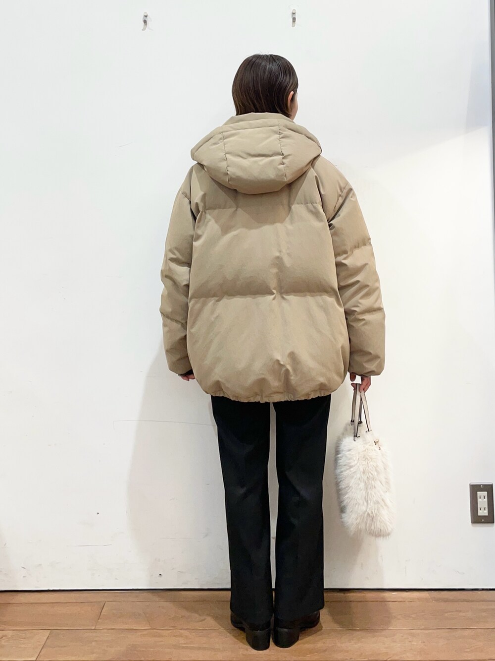 ブラウン系のダウンジャケット/コート、グレー系のニット/セーター、ブラック系のブーツを着用したレディースの冬コーディネートの4枚目の写真