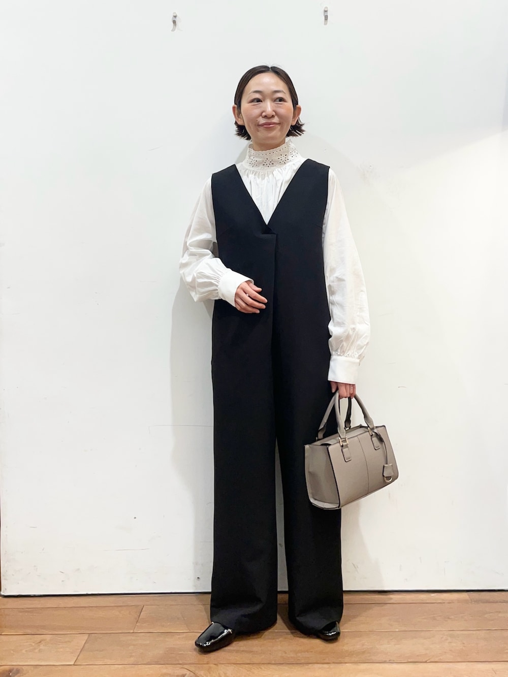 ブラック系のその他パンツ、ホワイト系のシャツ/ブラウス、グレー系のハンドバッグを着用したレディースの冬コーディネートの3枚目の写真