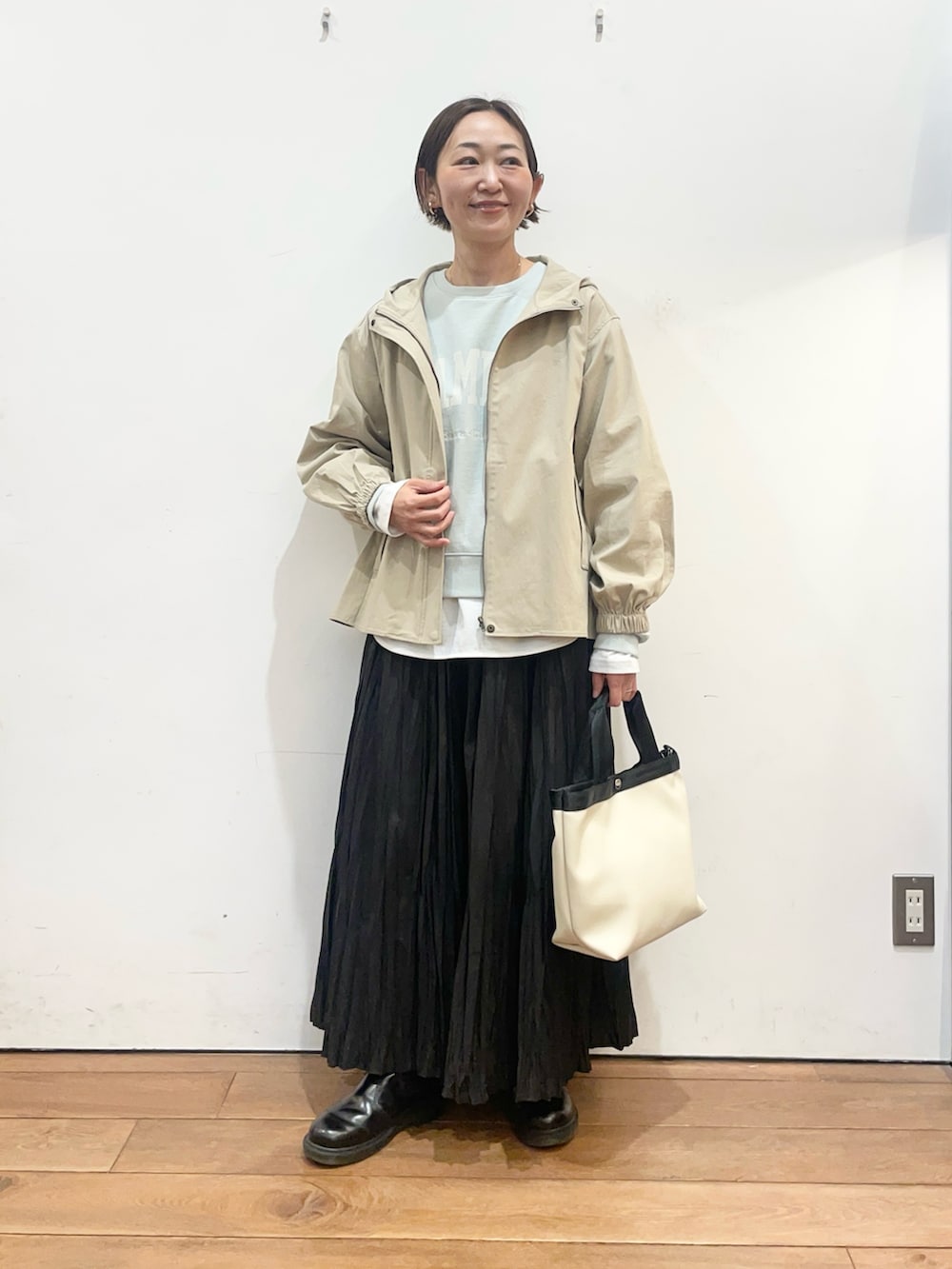 ベージュ系のその他アウター、グリーン系のスウェット、ホワイト系のTシャツ/カットソーを着用したレディースの春コーディネートの2枚目の写真