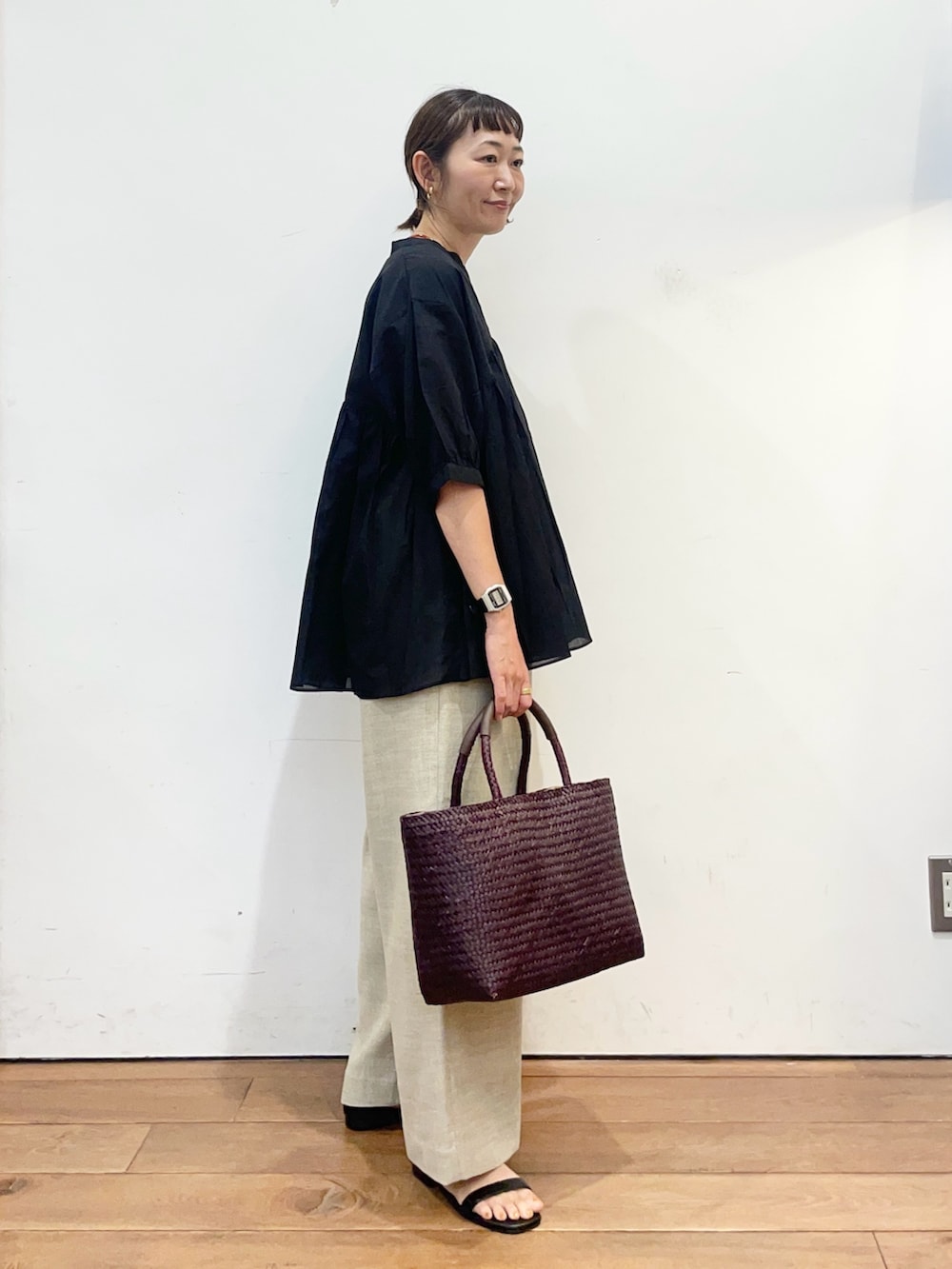 ブラック系のシャツ/ブラウス、ベージュ系のその他パンツ、ブラウン系のトートバッグを着用したレディースの夏コーディネートの3枚目の写真