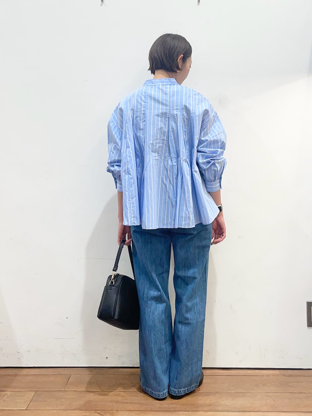 ブルー系のシャツ/ブラウス、ブラック系のショルダーバッグ、ブラック系のパンプスを着用したレディースの春コーディネートの4枚目の写真