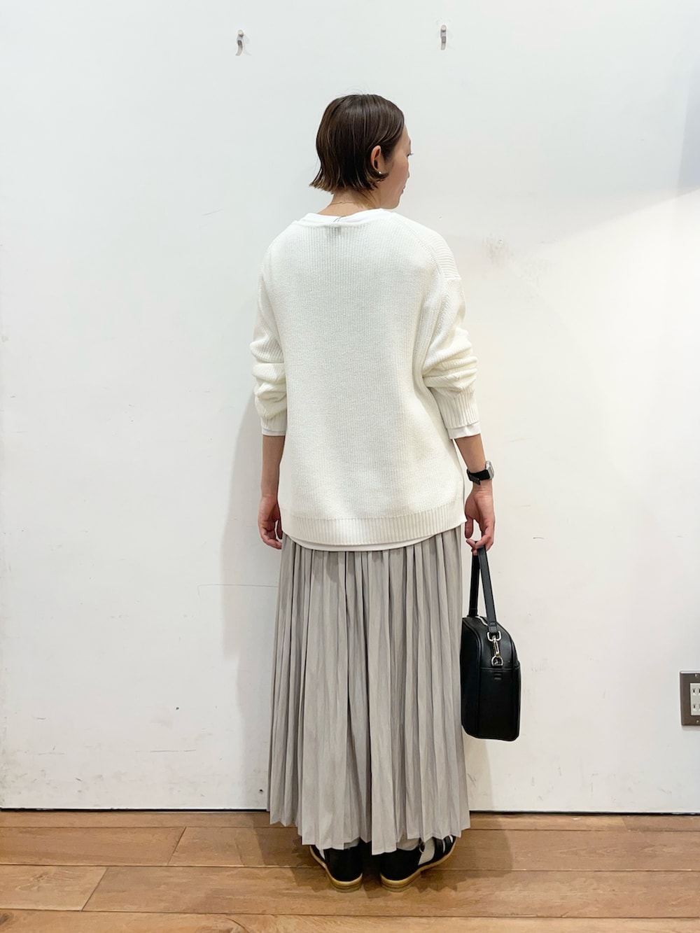 ホワイト系のニット/セーター、ホワイト系のTシャツ/カットソー、ベージュ系のスカートを着用したレディースの春コーディネートの4枚目の写真