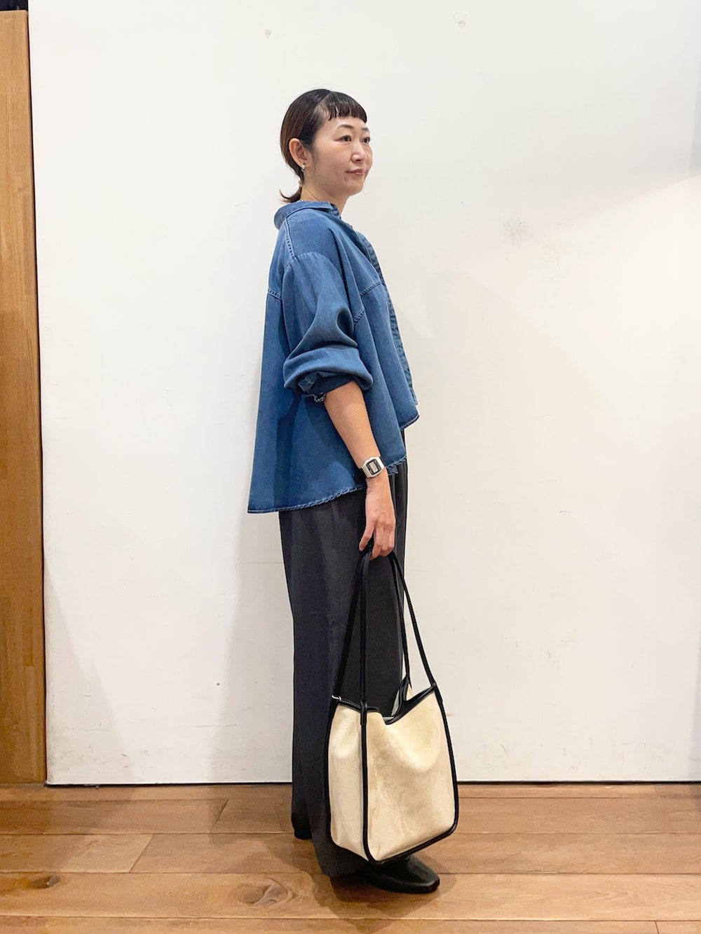 ブルー系のシャツ/ブラウス、ベージュ系のトートバッグ、ブラック系のスリッポンを着用したレディースの秋コーディネートの4枚目の写真