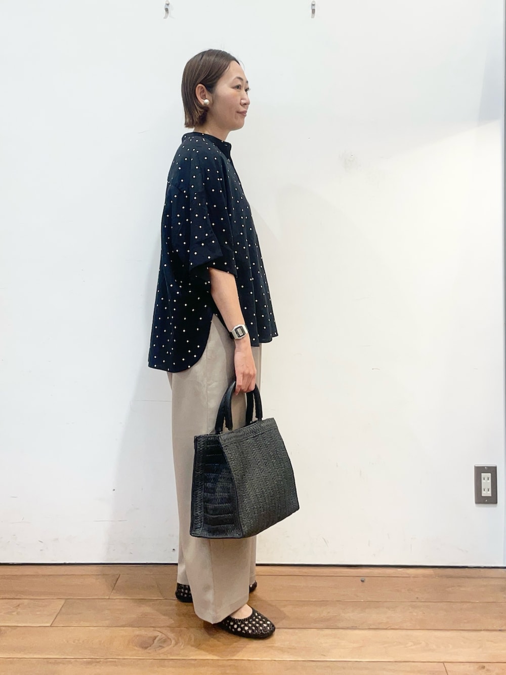 ブラック系のシャツ/ブラウス、ブラック系のサンダル、ブラック系のハンドバッグを着用したレディースの春コーディネートの4枚目の写真