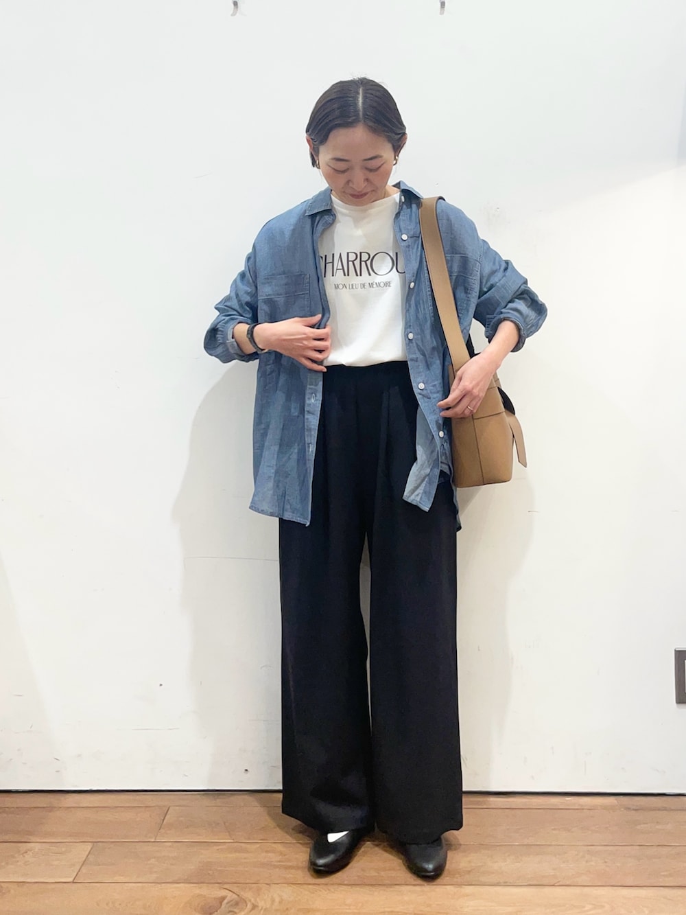 ブルー系のシャツ/ブラウス、ブラック系のパンプス、イエロー系のショルダーバッグを着用したレディースの春コーディネートの3枚目の写真