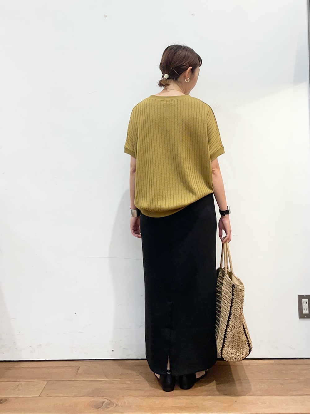 イエロー系のTシャツ/カットソー、ベージュ系のトートバッグ、ブラック系のスカートを着用したレディースの夏コーディネートの5枚目の写真