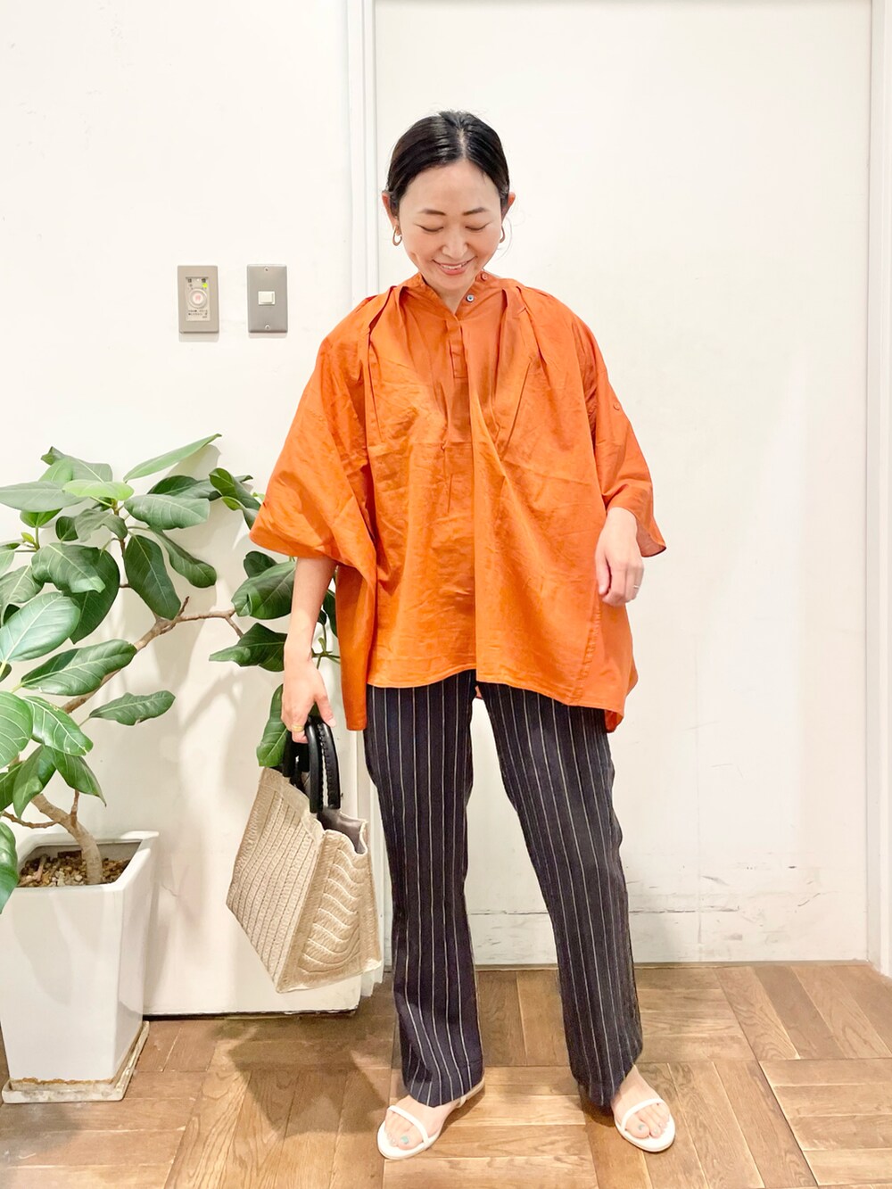 オレンジ系のシャツ/ブラウス、グレー系のその他パンツ、ホワイト系のサンダルを着用したレディースの夏コーディネートの3枚目の写真
