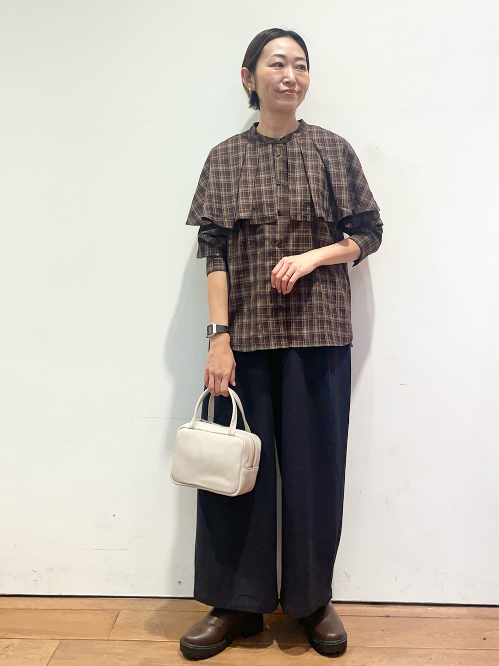 ブラウン系のブーツ、グレー系のボストンバッグ、ブルー系のその他パンツを着用したレディースの秋コーディネートの3枚目の写真