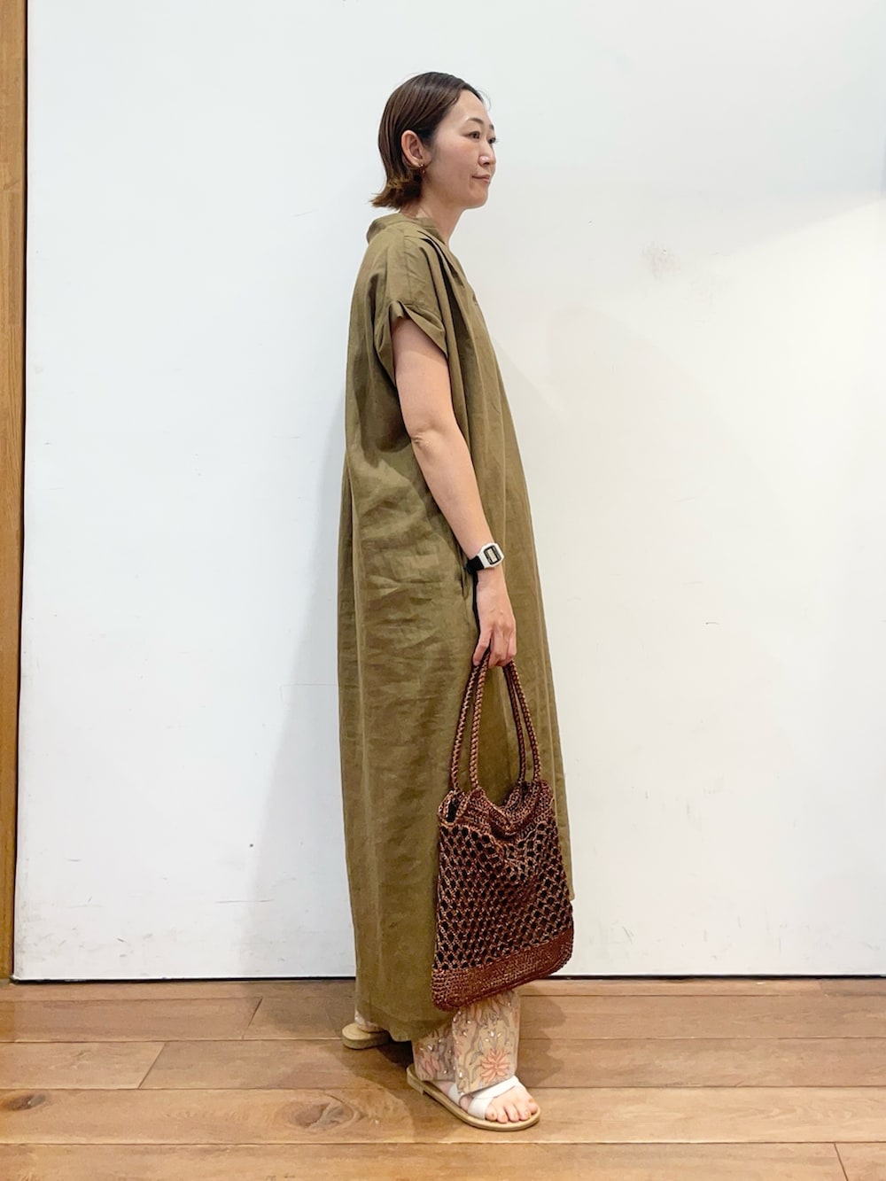 ベージュ系のワンピース、ブラウン系のトートバッグ、ホワイト系のサンダルを着用したレディースの夏コーディネートの4枚目の写真