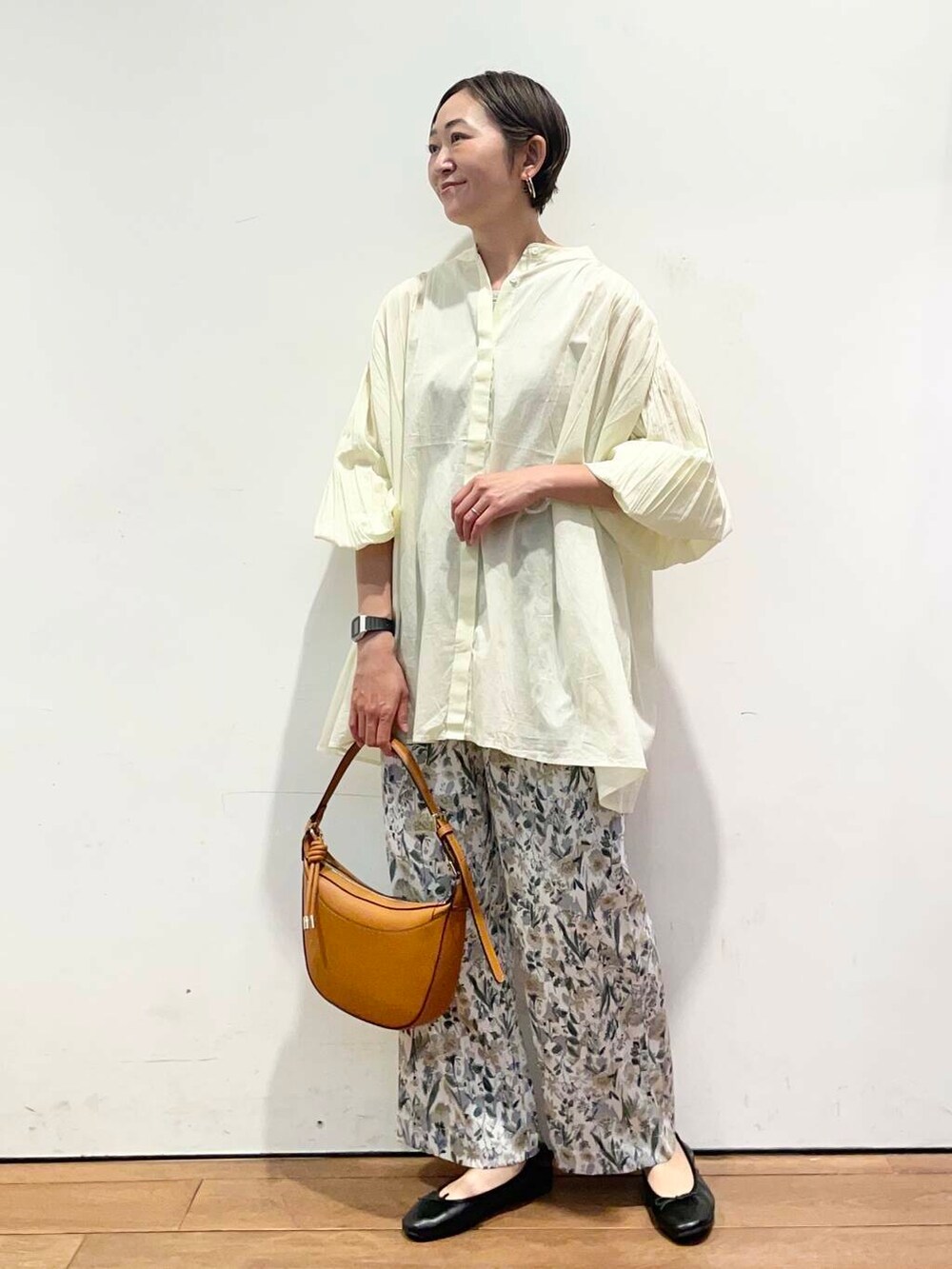 イエロー系のハンドバッグ、ベージュ系のその他パンツ、イエロー系のシャツ/ブラウスを着用したレディースの春コーディネートの2枚目の写真