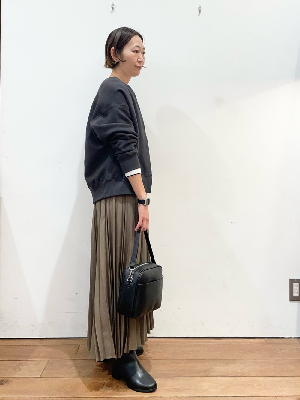 ベージュ系のスカート、ブラック系のショルダーバッグ、グレー系のカーディガン/ボレロを着用したレディースの冬コーディネートの3枚目の写真