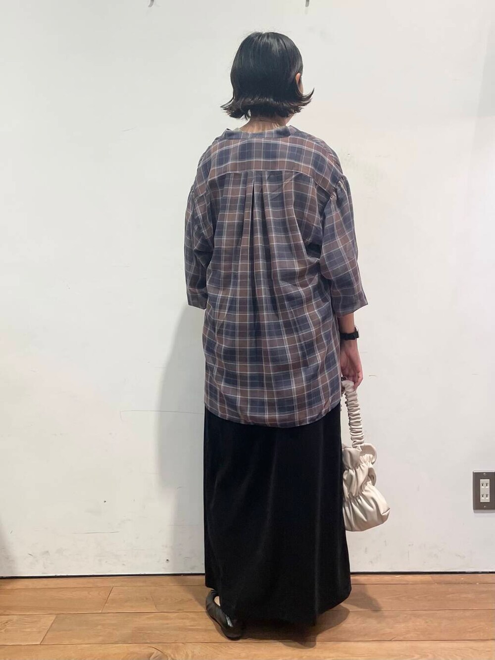 ホワイト系のハンドバッグ、ブラック系のワンピース、ブラック系のスカートを着用したレディースの秋コーディネートの8枚目の写真