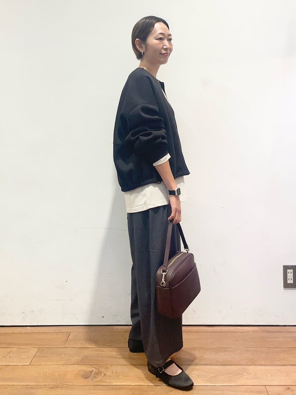 ベージュ系のTシャツ/カットソー、ブラック系のカーディガン/ボレロ、グレー系のその他パンツを着用したレディースの秋コーディネートの4枚目の写真