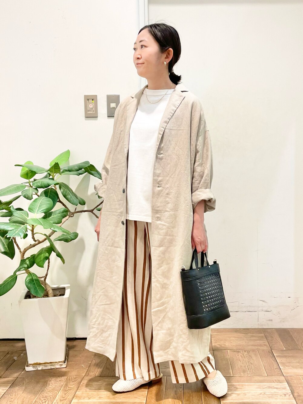 ブラック系のショルダーバッグ、ホワイト系のその他パンツ、ホワイト系のサンダルを着用したレディースの春コーディネートの3枚目の写真